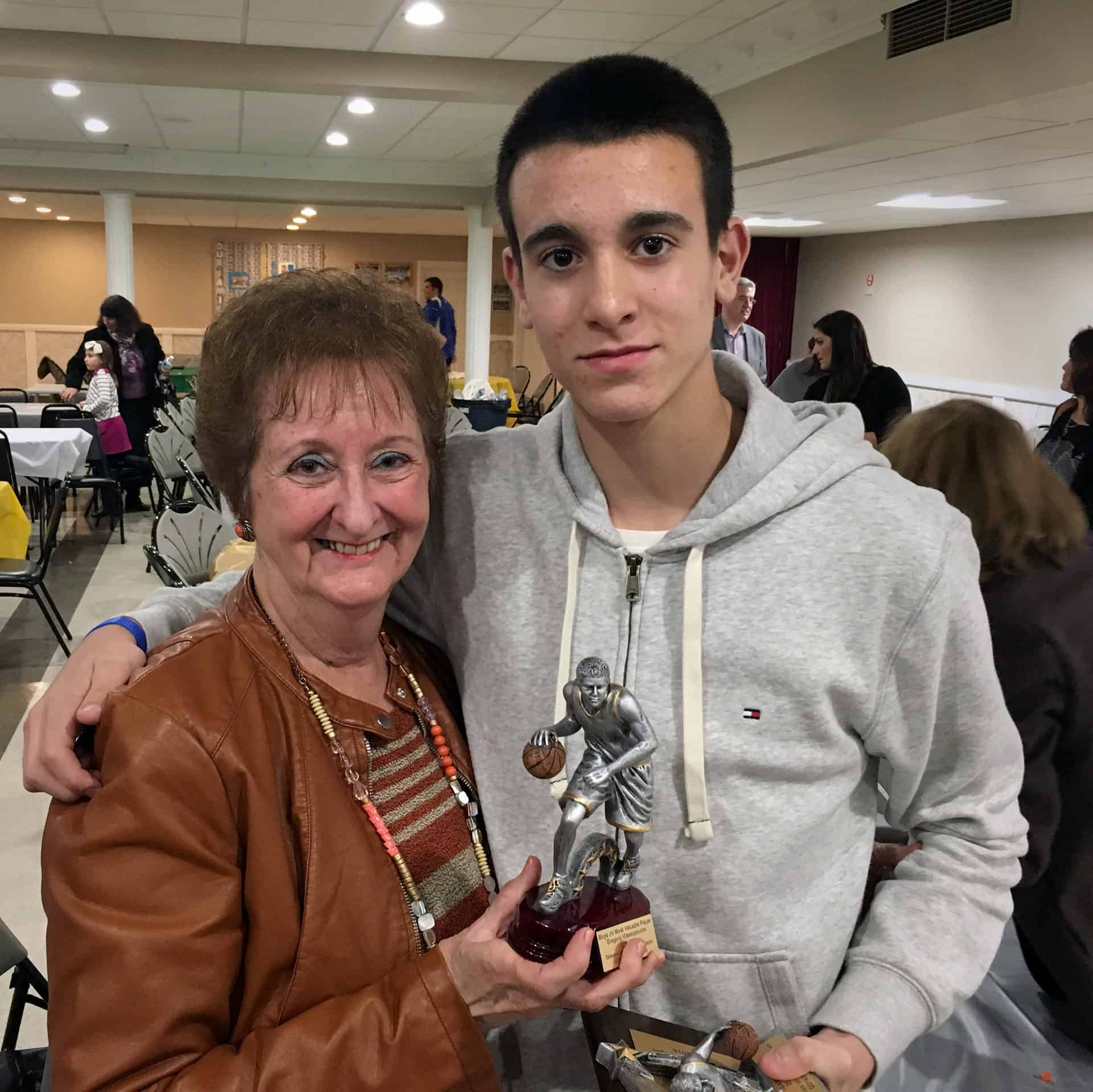 Greg Vlassopoulos with his grandmother at the GOYA Awards Ceremony holding the MVP trophy